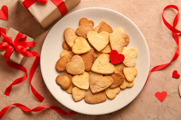 Plate with tasty heart shaped cookies and gifts on color background. Valentines Day celebration