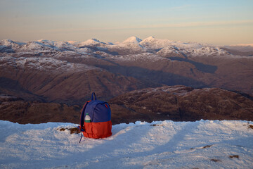 Evening view from the summit of Ben Lomond to the neighbouring peaks at sunset. In the foreground a...