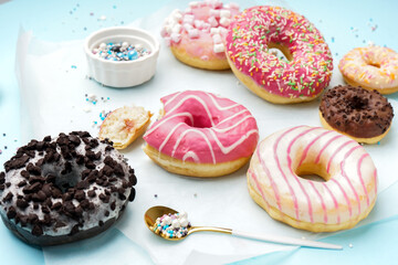 Parchment with different delicious donuts on blue background