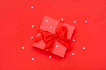 Gift box with beads on red background. Valentines Day celebration
