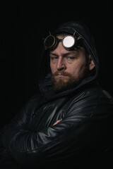 A man in a hood, wearing vintage steampunk goggles looking at the camera close-up