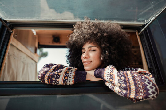 Woman relaxing in the window of her camper van