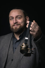 charismatic man in a classic suit and steampunk goggles on a black background stylish Portrait