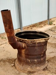 An old rusty stove in the yard. Homemade metal stove on the street.