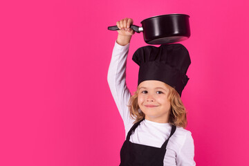 Kid chef cook with cooking pot. Child chef cook, studio portrait. Kids cooking. Teen boy with apron and chef hat.
