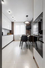 Modern cuisine in black in the dining table and kitchen appliances