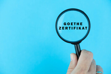 Focused on Goethe Zertifikat exam. Word Goethe Zertifikat under magnifying glass. German or Dutch...