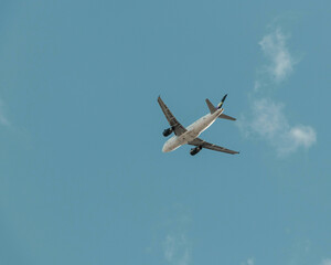 Fototapeta na wymiar Avión volando con cielo azul y nubes