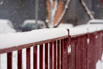 The fence is covered with snow. Winter time of the year.