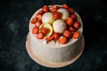 biscuit cake decorated with strawberries and chocolate balls