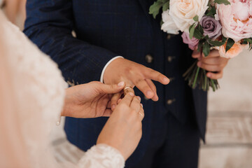 the bride puts on the ring to the groom at the ceremony close-up