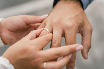 bride puts wedding ring on groom