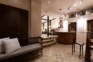 Waiting room of a restaurant with a madra armchair with gray and white cushions