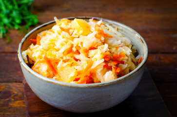 Sauerkraut, Shredded cabbage, apples, and carrots on dark rustic background, Fermented Food, Healthy Eating