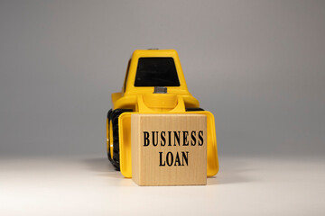 Business loan text. It is written on a wooden surface. The background is white.