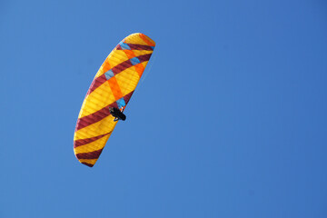 a man flies on a paraglider in a clear blue sky close-up