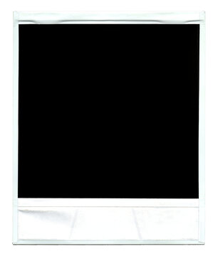 The isolated dirty white frame of an old instant photo (like those produced by the obsolete Polaroid camera), retro vintage item, black surface.
