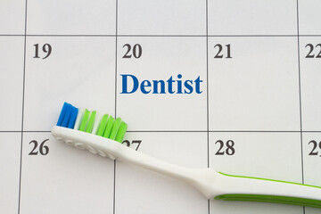 Toothbrush on a calendar for scheduling dentist appointment