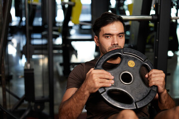 young athletic man exercise with weight lifting rubber plates in the gym