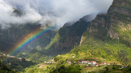 Tropical landscape with rainbow and clouds