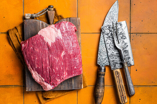 Whole Piece Of Raw Beef Brisket Meat. Orange Background. Top View