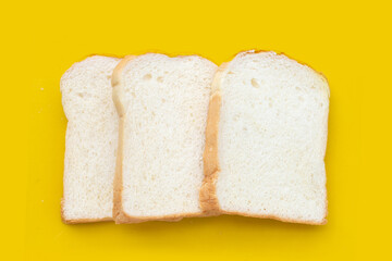 Stack of sliced bread on yellow background.