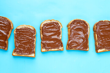 Bread with sweet chocolate hazelnut on blue background.