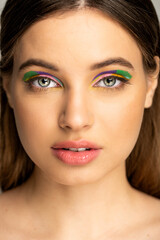 Obraz premium Teenage girl with colorful makeup looking at camera isolated on grey.