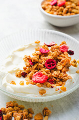 Granola with Yogurt in a Boal, Healthy Breakfast, Muesli with Dried Berries on Bright Concrete Background