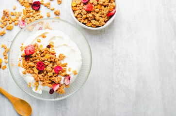 Granola with Yogurt in a Boal, Healthy Breakfast, Muesli with Dried Berries on Bright Concrete Background