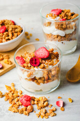 Granola and Yogurt Parfaits, Healthy Breakfast or Snack, Muesli with Dried Berries on Bright Concrete Background