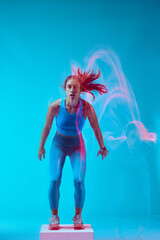 A sportswoman doing box jumps and exercising. Long exposure capture movement.