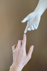 two hands, the hand of a statue and the hand of a man reaching for each other with fingers....