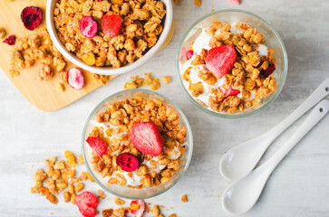 Granola and Yogurt Parfaits, Healthy Breakfast or Snack, Muesli with Dried Berries on Bright Concrete Background