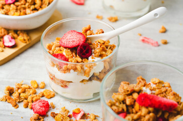 Fototapeta na wymiar Granola and Yogurt Parfaits, Healthy Breakfast or Snack, Muesli with Dried Berries on Bright Concrete Background