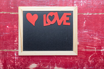 photo Frame, heart and word LOVE for Valentine's Day on a red wooden table. Top view with copy space