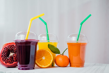 Fresh juices. Assortment of colored fruit juices to take away in a plastic glass