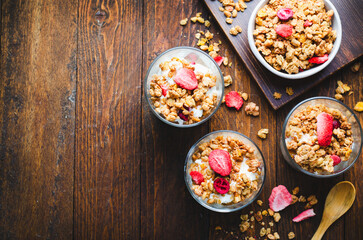 Granola and Yogurt Parfaits, Healthy Breakfast or Snack, Muesli with Dried Berries on Wooden Background