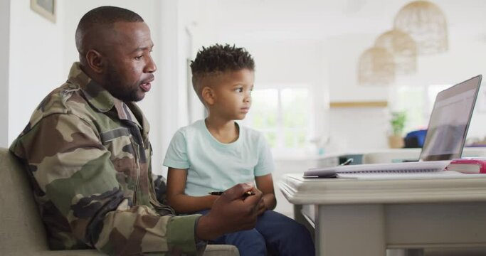 African american father with son learning together with laptop