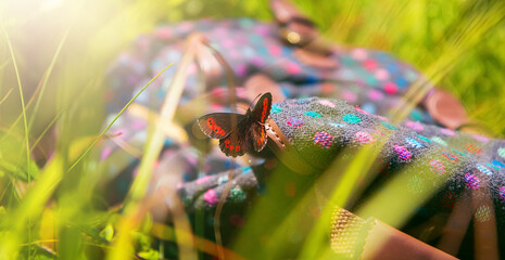 A beautiful butterfly sits on a backpack. A summer photo that inspires travel.