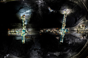 Rotary shovel at coal pile, bulk shipping terminal, silos, grain elevators, freight vessels, North Vancouver, BC.