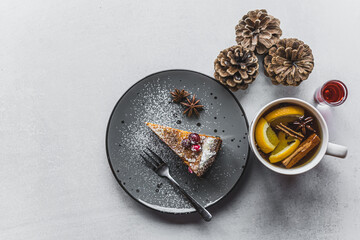top view of a delicious cake on a gray plate, a cup of tea and pine cones next to it, winter aesthetic. High quality photo