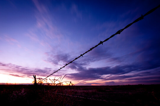 Fence with pink and purple clouds.  La Junta, Colorado.