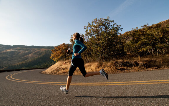 An athletic woman jogging in the Columbia Gorge, Oregon.