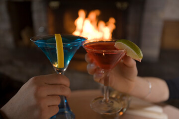 Two people making a toast in front of a fire in Kirkwood, California.
