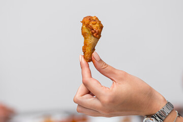 close up of a person holding chicken wing