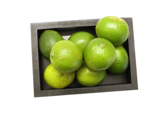 Fresh ripe lime isolated in wooden crate on white background 