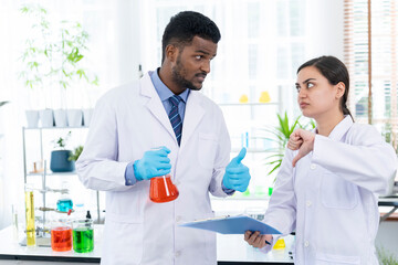 Two Young researcher analyzing liquid in tube at laboratory