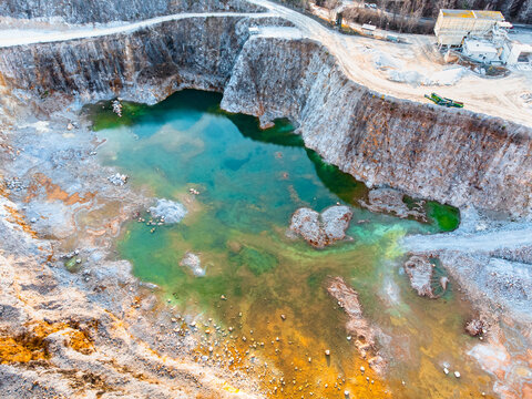 Open stone quarry pit filled with green algae water © MVProductions