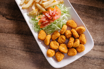 Nuggets de pollo con ensalada y papas a la francesa 